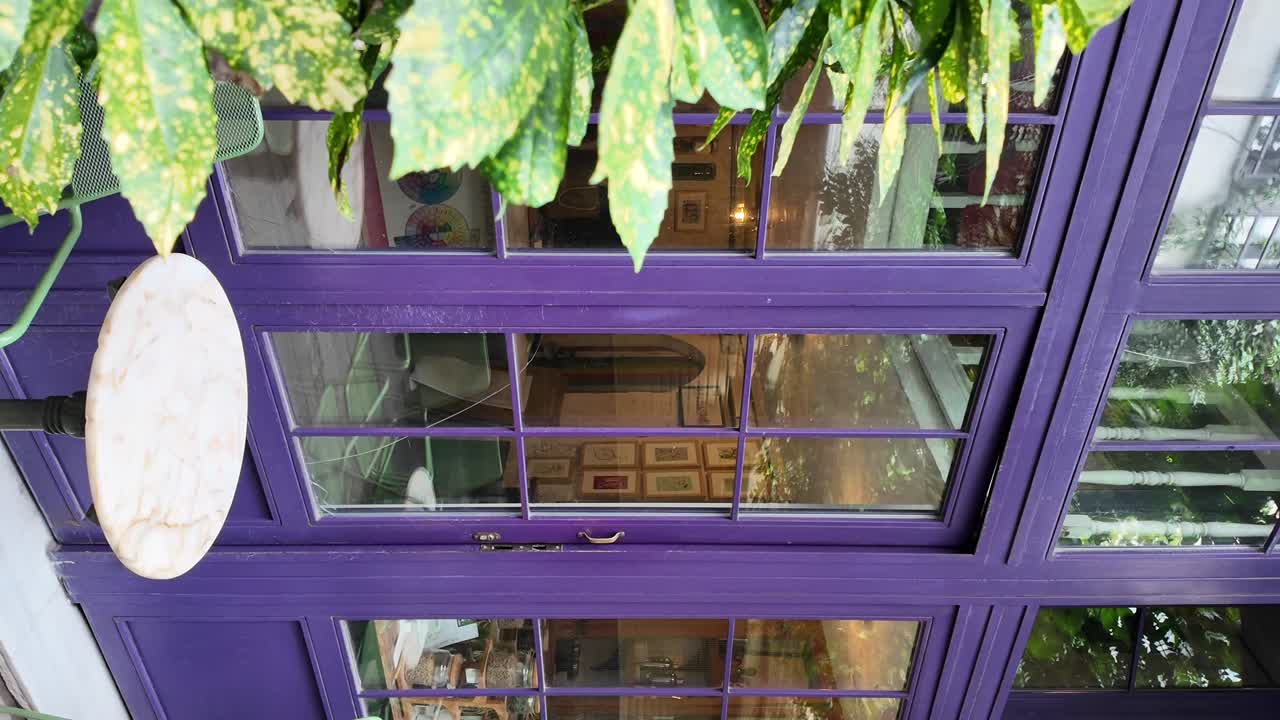 Charming Cafe Exterior with Purple Windows and Outdoor Seating