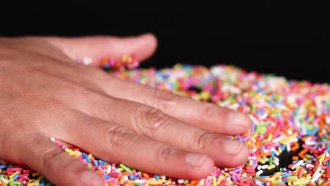 hands interacting with colorful sprinkles