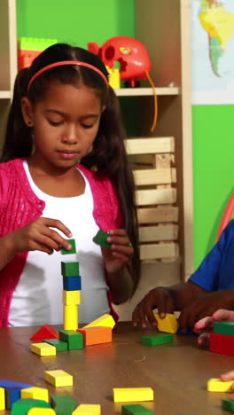 cute classmates playing with building blocks