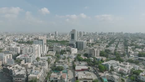 aerial drone forward moving shot over residential houses and office buildings on both sides of shahrah e qaideen road, karachi metropolitan city, pakistan on a sunny day