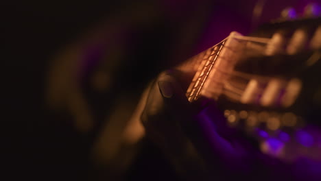um close-up de uma pessoa a tocar guitarra numa apresentação.