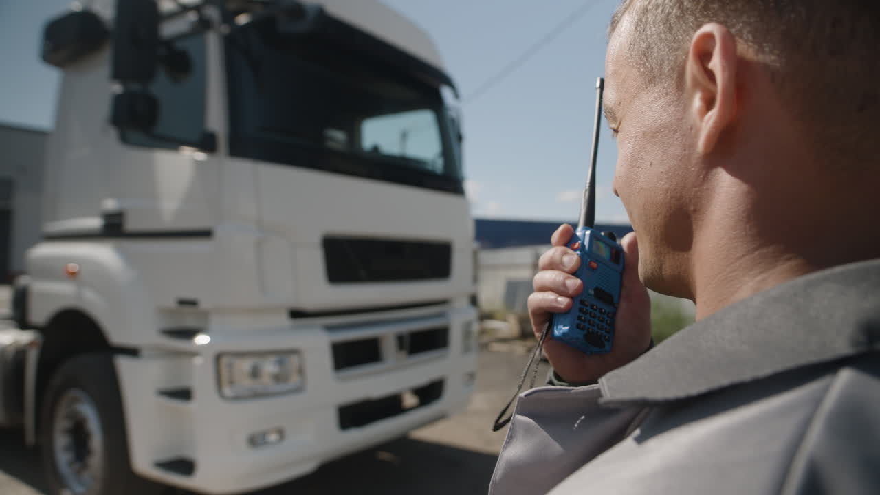 Man with walkie-talkie near a truck