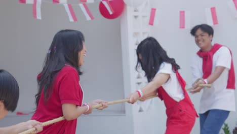 young asian people doing tug of war competition on indonesia independence day