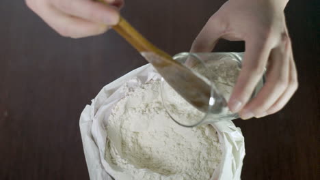 baker puts flour in glass. white weat flour. home baking ingredients