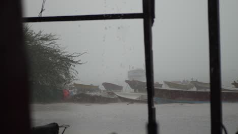 Blick-Durch-Das-Fenster-Durch-Starken-Regen,-Der-Am-Bewölkten-Tag-Am-Fischerhafen-Von-Gwadar-Fällt