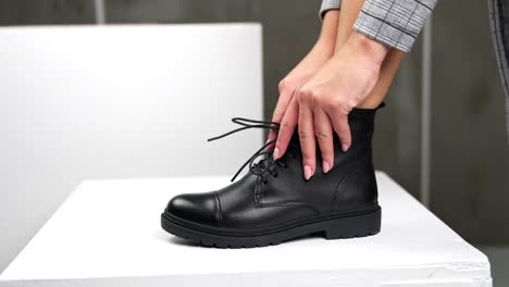 woman trying on black leather lace-up boots