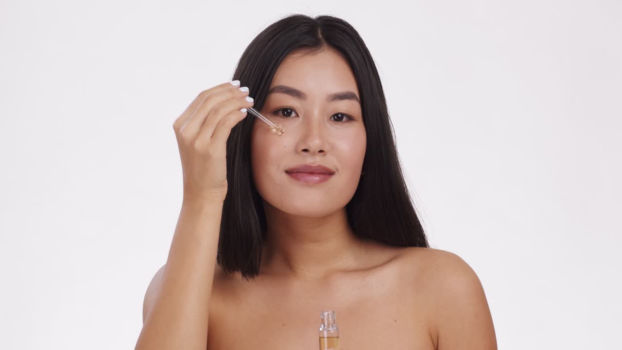 mujer aplicando aceite facial