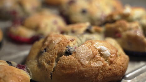 Pfanne-Mit-Frisch-Gebackenen-Muffins-Mit-Früchten-In-Bunten-Verpackungen-Auf-Einem-Metallbackblech