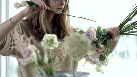 young florist assembles a rustic wedding bouquet