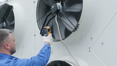 technician uses a thermal imaging infrared thermometer to check the condensing unit heat exchanger