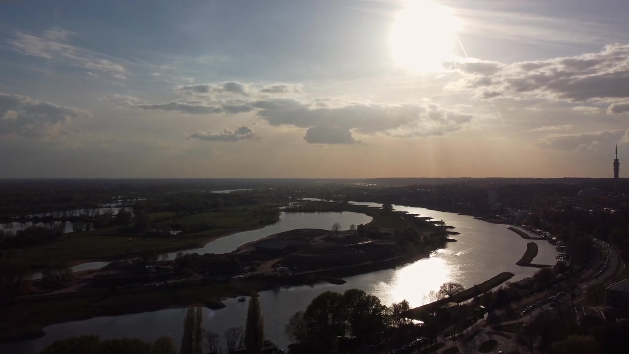 Fiume Nederrijn ad Arnhem, Gheldria, Paesi Bassi, all'interno del sistema del delta Reno-Mosa con argini, pianura alluvionale e strade arginali che mostrano ingegneria idraulica e gestione delle acque, drone in ascesa e panoramica