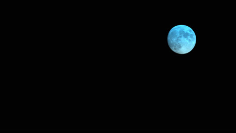 small rising full moon changing colours, astro time lapse