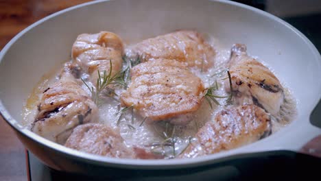 pollo frito dorado cocinado en sartén con salsa de ajo y hierbas