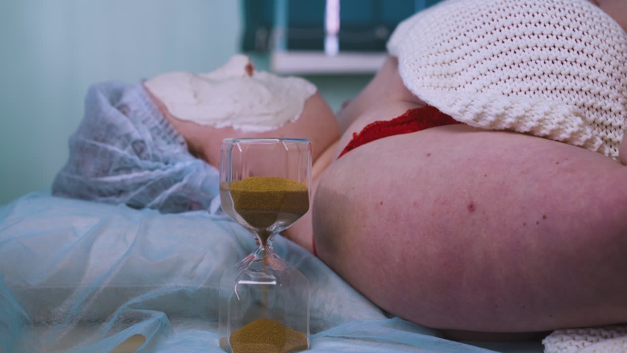 giovane donna con maschera di alginato sul viso e orologio di vetro