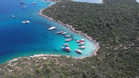 Drone-of-boats-parked-in-shallow-crystal-blue-waters-on-the-Turkish-Riviera-in-Bodrum