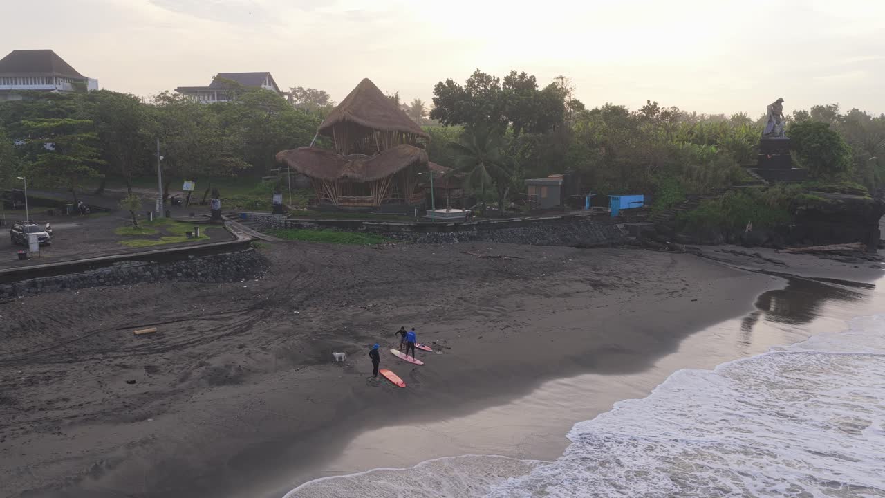 Surfisti sulla spiaggia di Kedungu a Bali, Indonesia, che entrano nell'oceano.