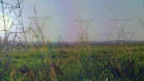 Composite-image-of-white-spots-against-time-lapse-of-green-and-electric-towers-against-blue-sky