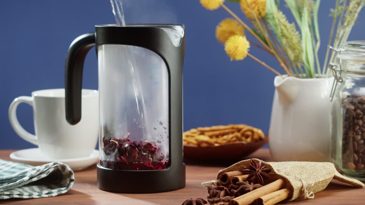 preparando té negro en una tetera de primer plano. bebiendo una bebida herbal caliente sobre un fondo azul