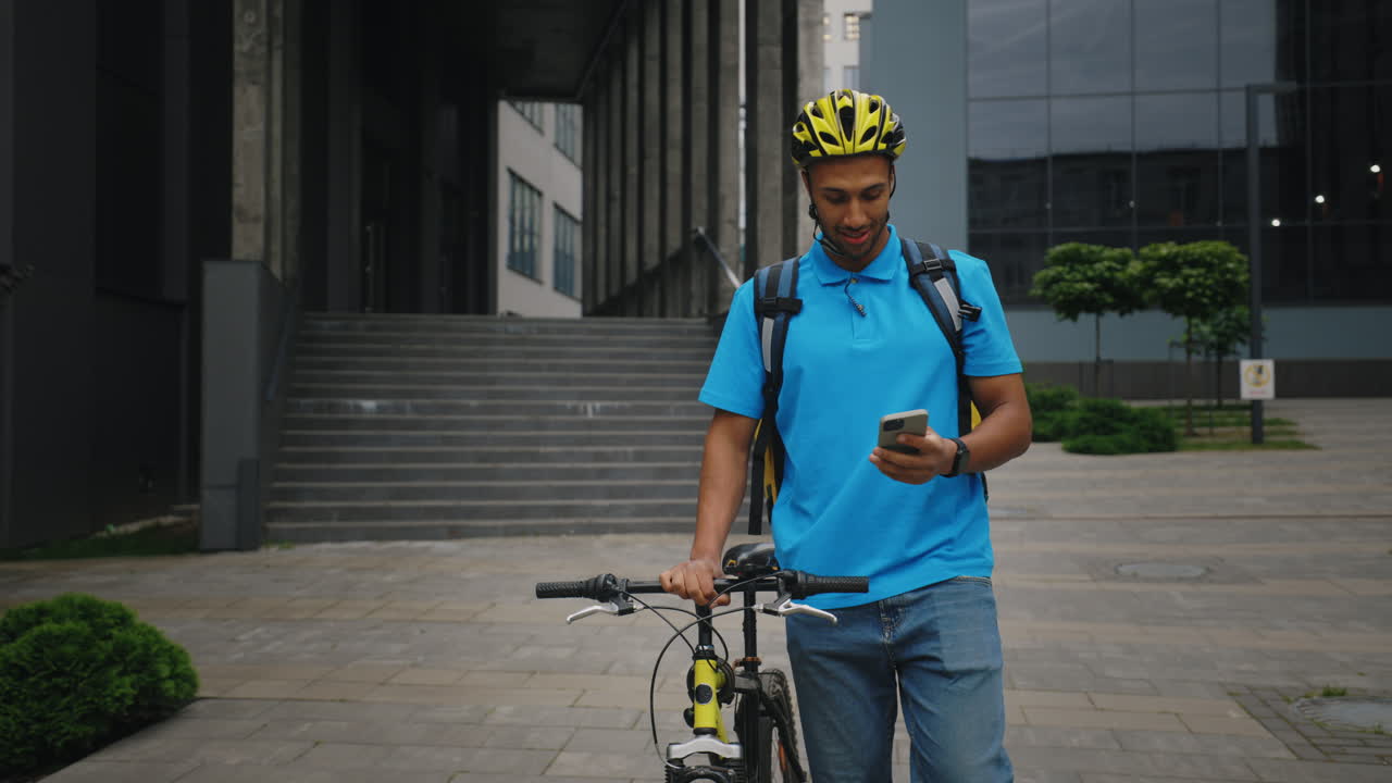 Delivery Person Walking with Bicycle and Smartphone