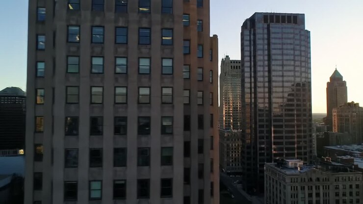 Uma Vista Deslumbrante do Pôr do Sol Sobre Arranha-Céus Urbanos com Reflexos e Cores Vibrantes, Capturada de uma Perspectiva Elevada em uma Noite Clara