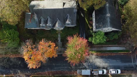 Descending-aerial-of-cyclist-on-bicycle-rides-on-street-through-town