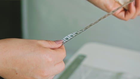 young seamstress works with tape measure to sew clothes