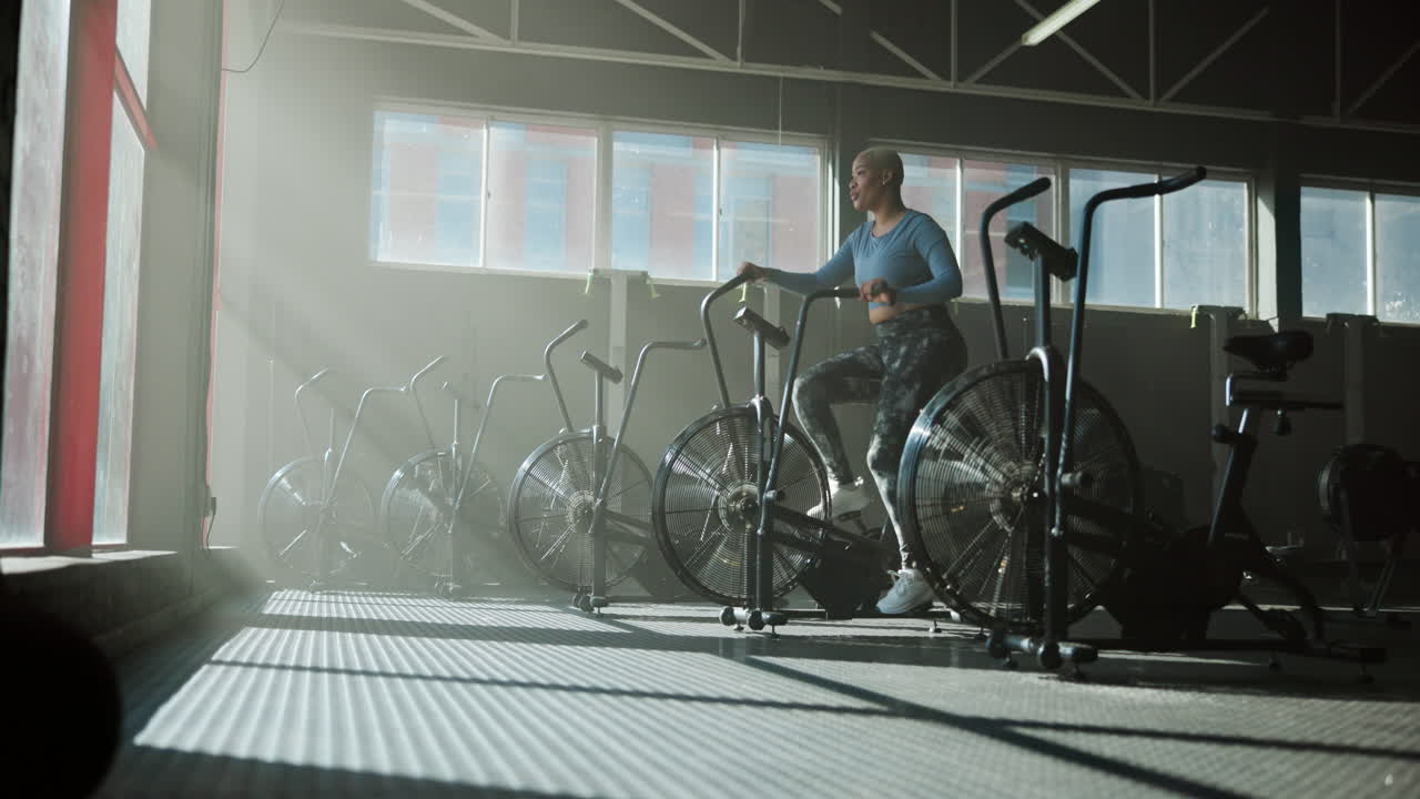 Woman exercising on stationary bike in gym
