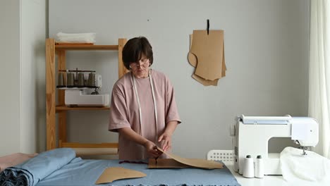 seamstress making clothes pattern in workshop