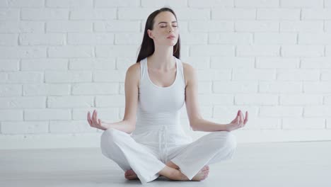 Young-woman-meditating-in-white-room