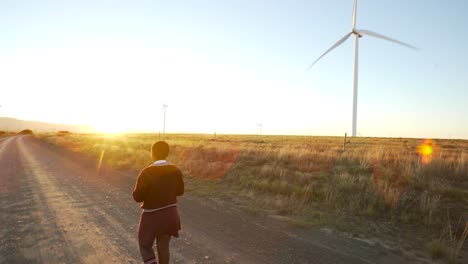 School-girl-walking-on-gravel-road-at-dawn