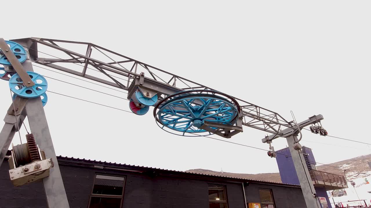 колесо подъемника, поднимающее лыжников на холм