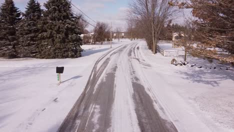 local empty rural country road covered in snow and ice, low altitude drone shot