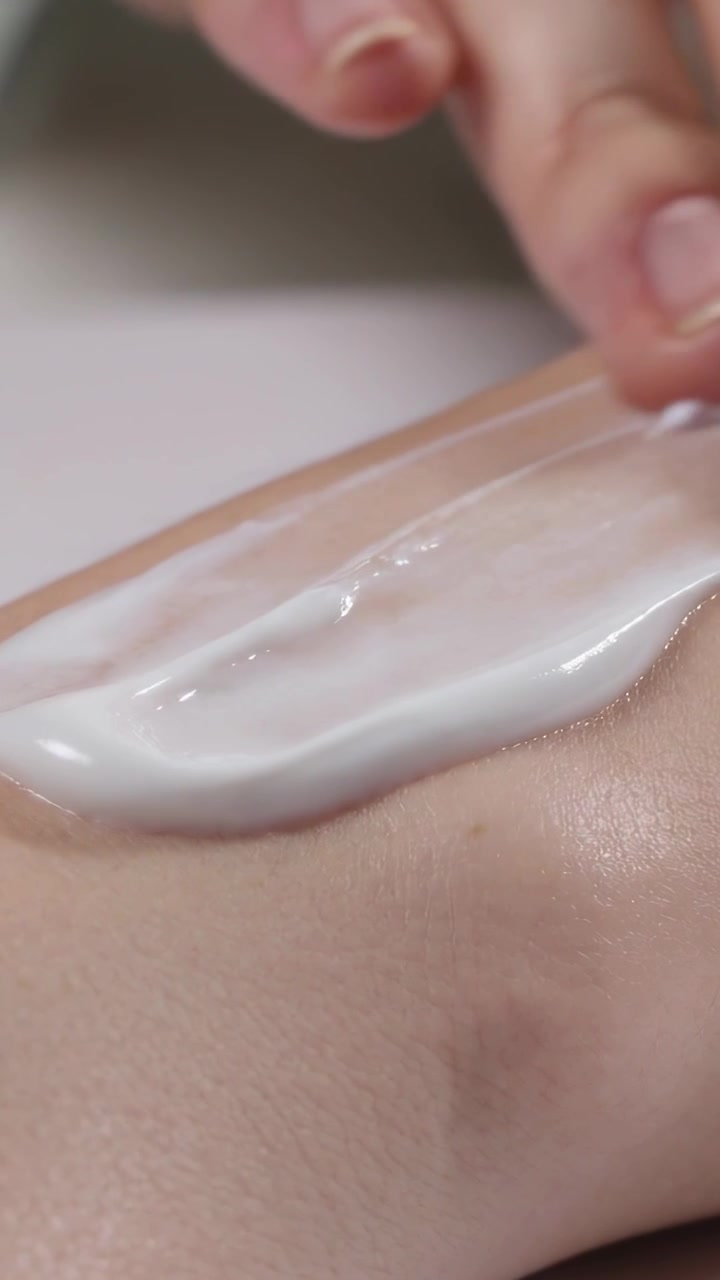 Vertikal video: Placerer dupende hånd, presser og trækker creme over torsohud på spa for jævn hudtone og modermærker.