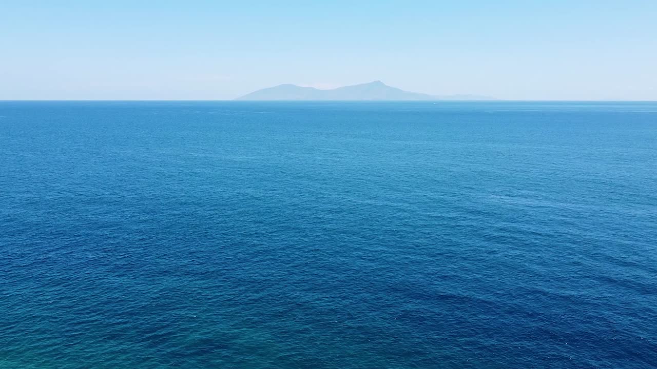 동티모르 수도 딜리, 동남아시아 수도 딜리에서 볼 수 있는 광활한 푸른 바다와 멀리 떨어진 험준한 열대 아타우로 섬 위로 공중 드론이 떠오른다