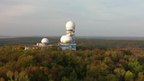 Spectacular-aerial-view-flight-wide-orbit-cinematic-drone-of-Radoms-in
autumn-forest-at-morning-sunrise,-devil's-mountain-in-woods-berlin-October-2022