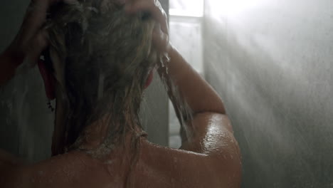 mujer lavando el cabello en la ducha