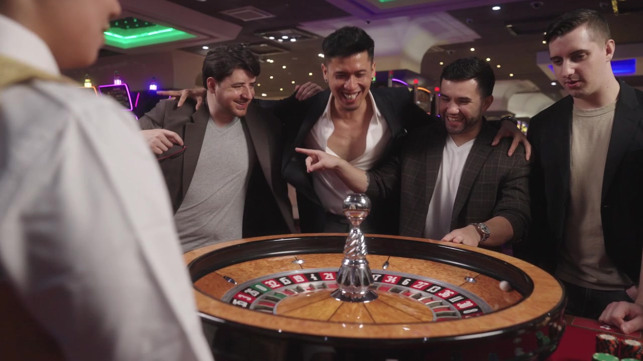 Filmato commerciale di roulette e baccarat giocati dai giocatori, circondati da moderne macchine da gioco da casinò.