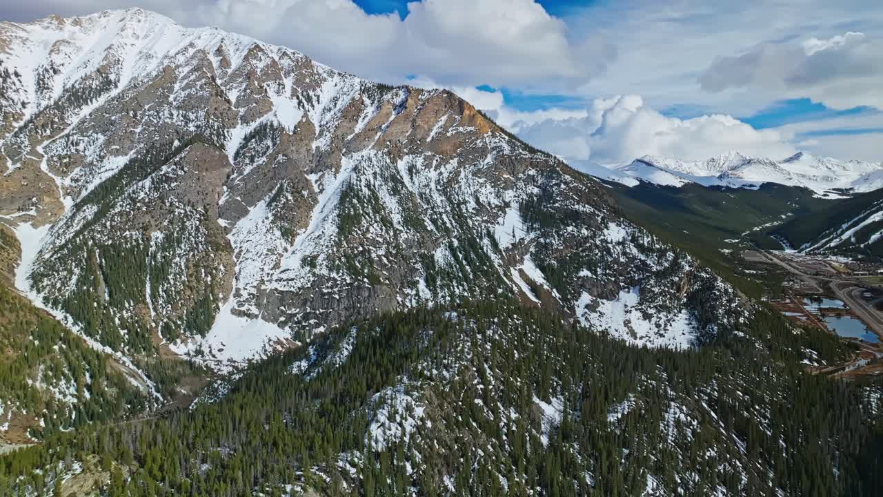 Ombre del fianco della montagna proiettate sul pendio alpino di Frisco Gulch e sulla pineta, ripresa aerea panoramica in allontanamento