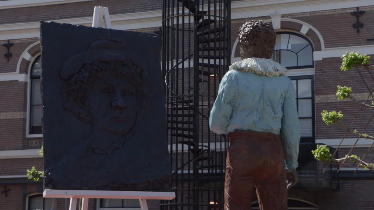 Statues of young Rembrandt van Rijn looking at old Rembrandt van Rijn