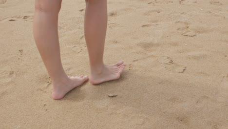 해변을 거니는 동안 젊은 아시아 여성의 발을 가까이서 보고 휴일 휴가를 보내는 동안 휴식을 취하세요