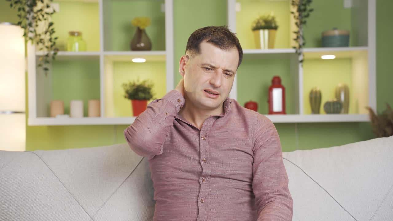 Hombre con dolor de cuello frotándose el cuello. Dolores articulares