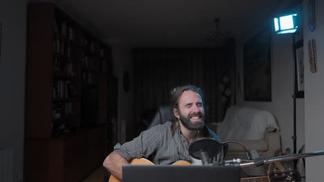 man playing acoustic guitar and singing at home