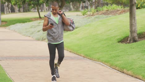 Side-view-man-with-prosthetic-leg-and-using-his-phone-while-walking