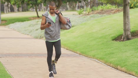 side view man with prosthetic leg and using his phone while walking