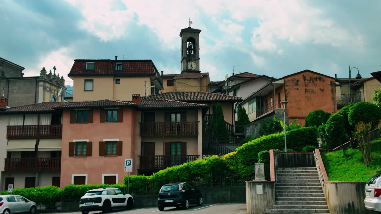 Scenic view of historic Italian village architecture featuring traditional stone buildings and bell tower under cloudy sky in Cividate Camuno, Brescia, Lombardy region of Northern Italy