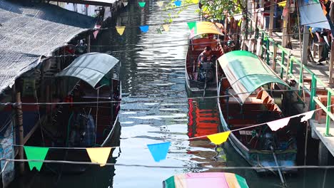 boats move through a bustling canal market