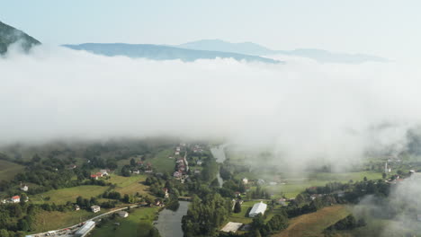 beautiful valley with houses under clouds and mountain in peaceful setting