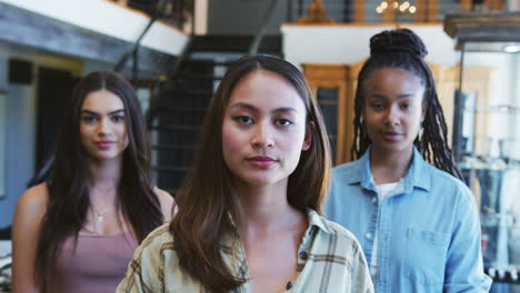 retrato de un equipo de ventas femenino multicultural sonriente en una tienda de moda frente a una exhibición de ropa