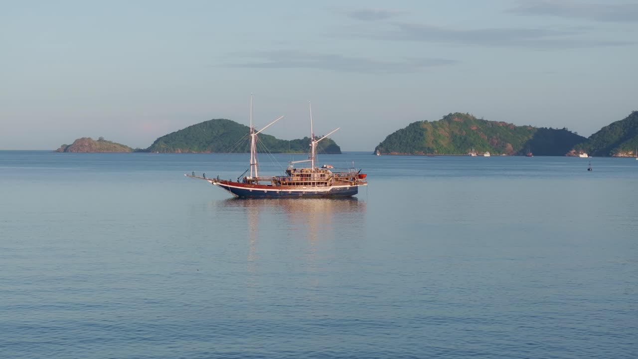 Kapal-kapal berlabuh di perairan tenang saat fajar, Labuan Bajo, Flores, Indonesia