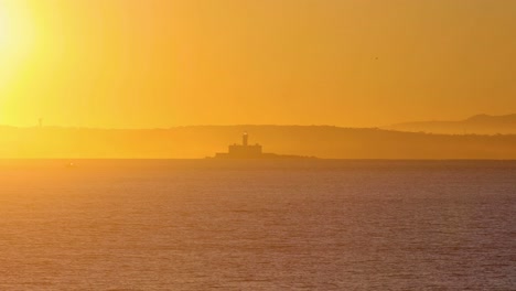 high-quality-footage-shows-the-picturesque-Lisbon-coast-under-a-sunrise-sky,-featuring-the-prominent-Forte-do-Bugio-lighthouse-set-offshore